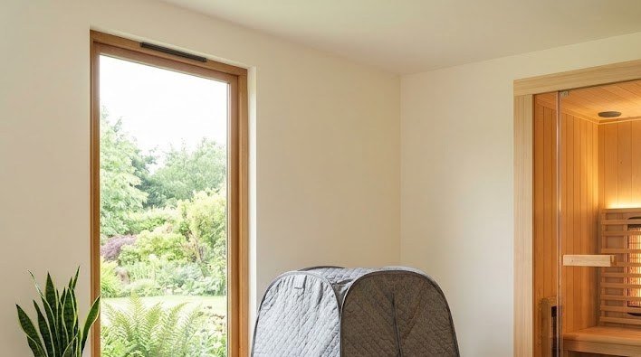 Infrared home sauna next to a portable sauna tent and a sauna blanket